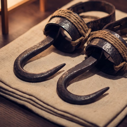 Tekagi, climbing claws — a pair, photographed on unbleached hemp cloth.